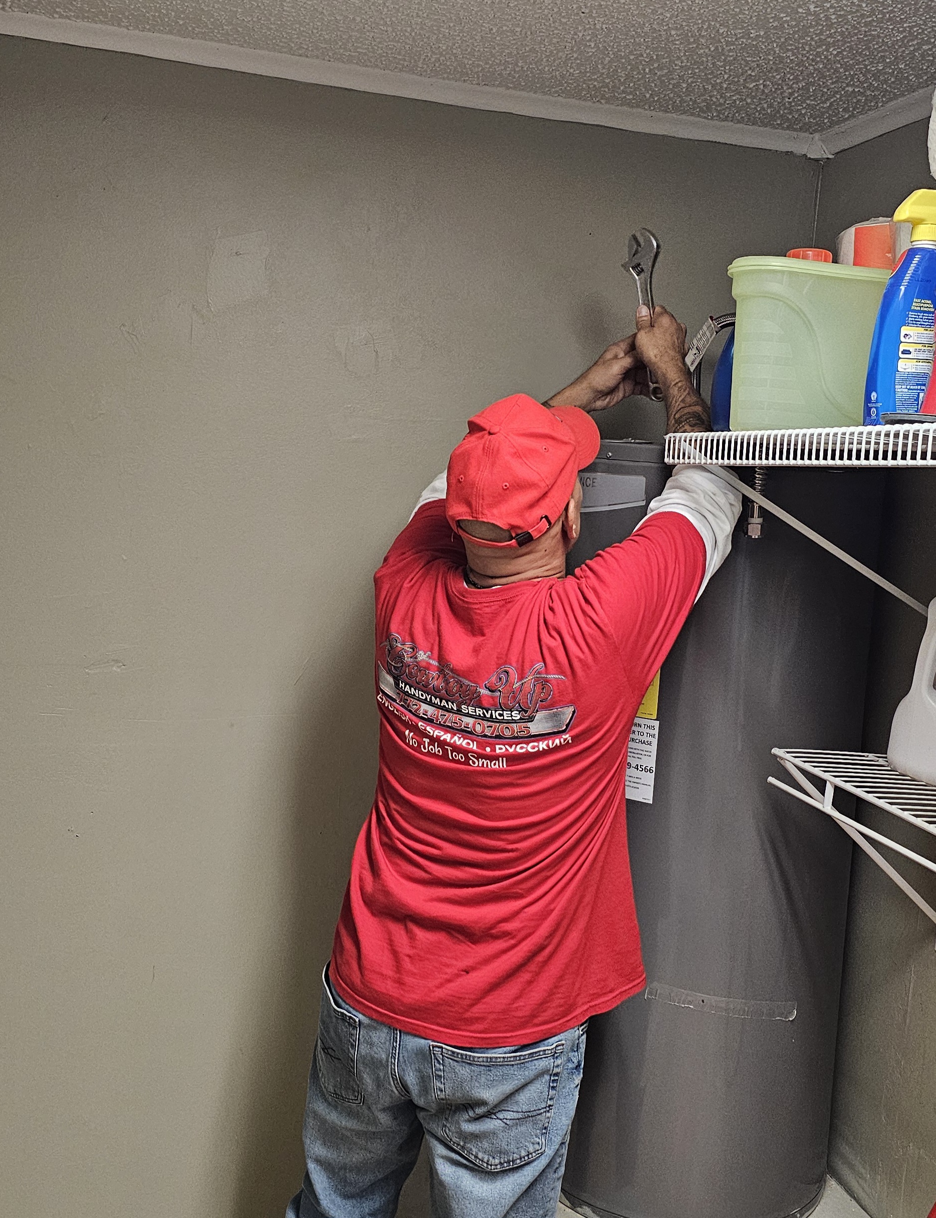 Cowboy Up handyman working on a water heater plumbing connection